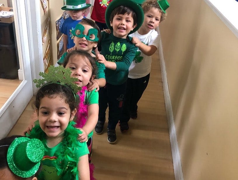 Children in green costumes and hats standing in a line