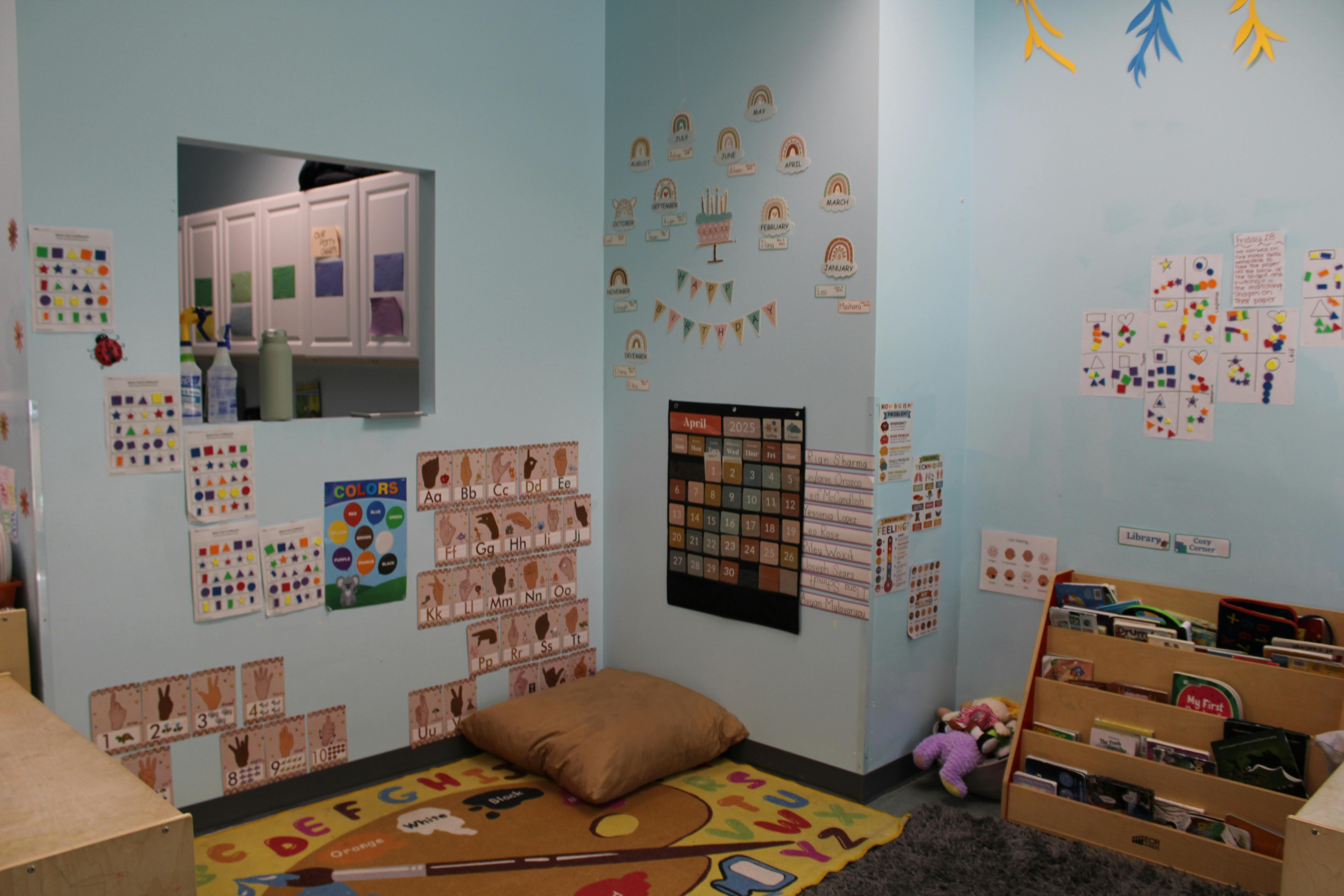 Classroom corner with an alphabet rug, calendar, and reading nook