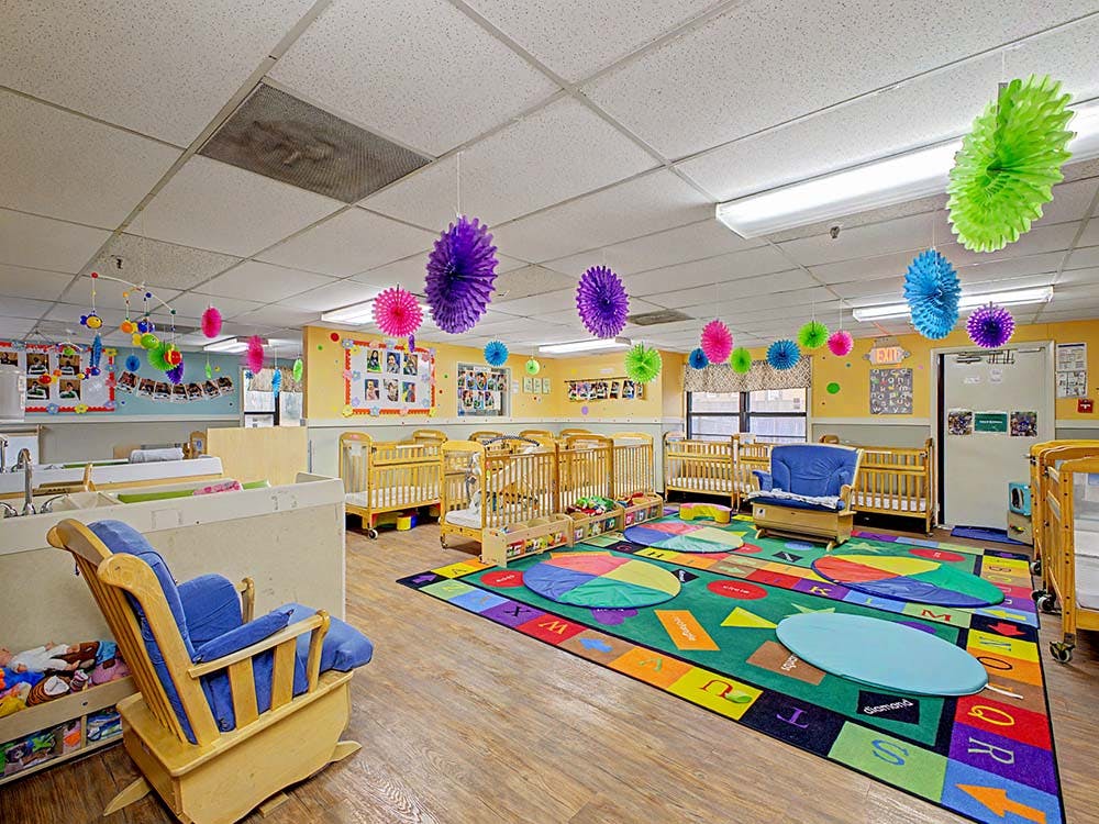 Baby nursery with cribs, rocking chairs, and colorful rug