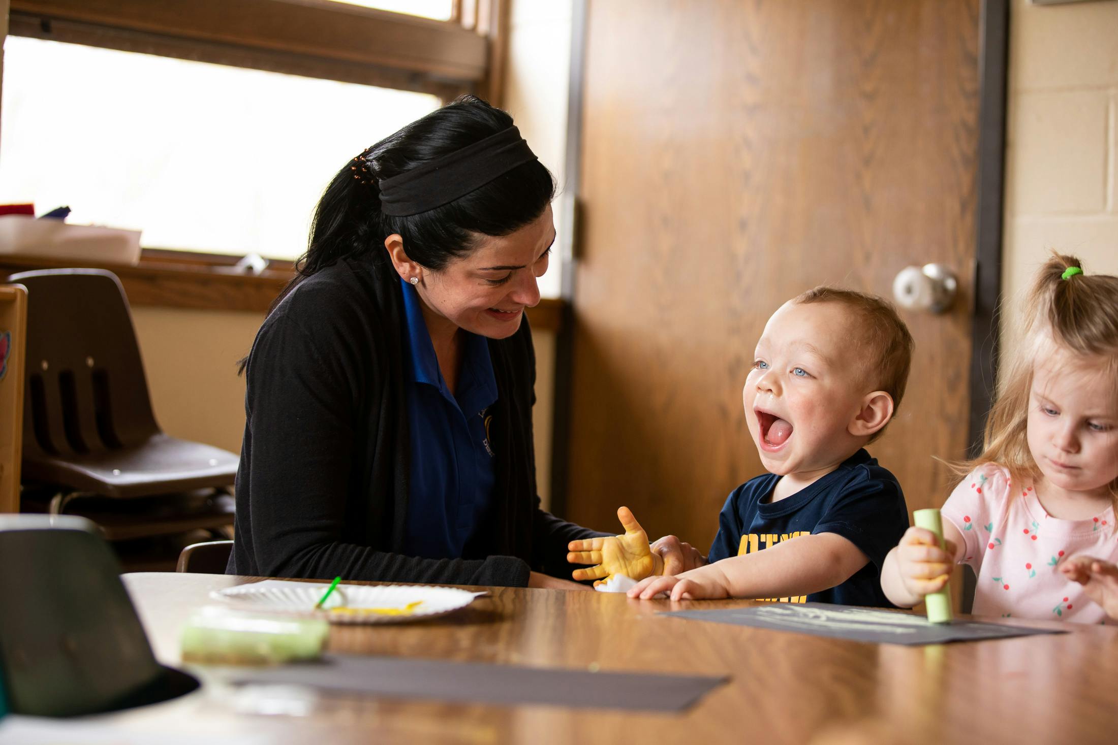 Adult and two children at a table