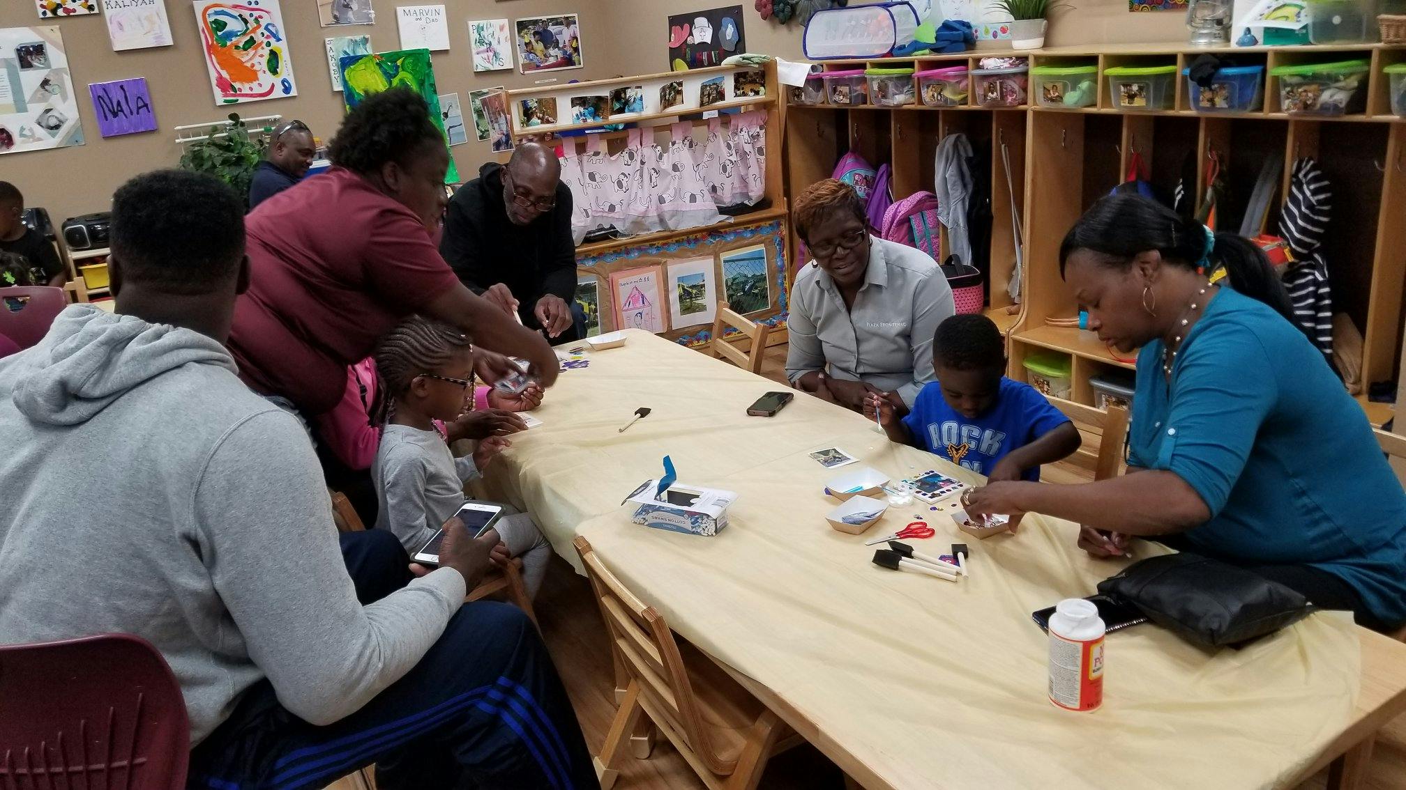 People and children sitting at a table in a classroom
