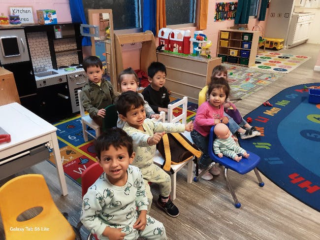 Group of children seated on small chairs in a classroom