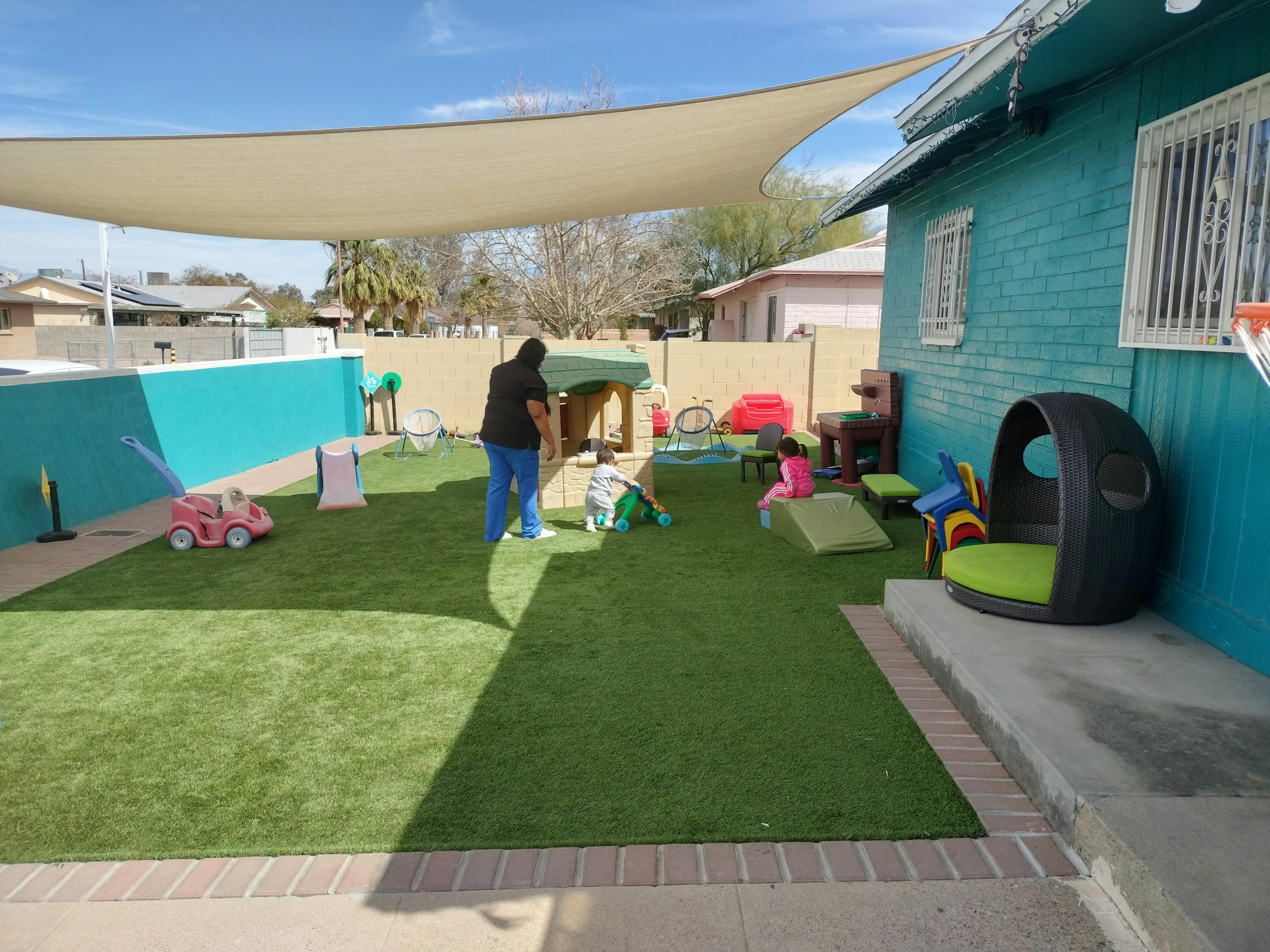 Person standing in a play area with artificial grass and toys