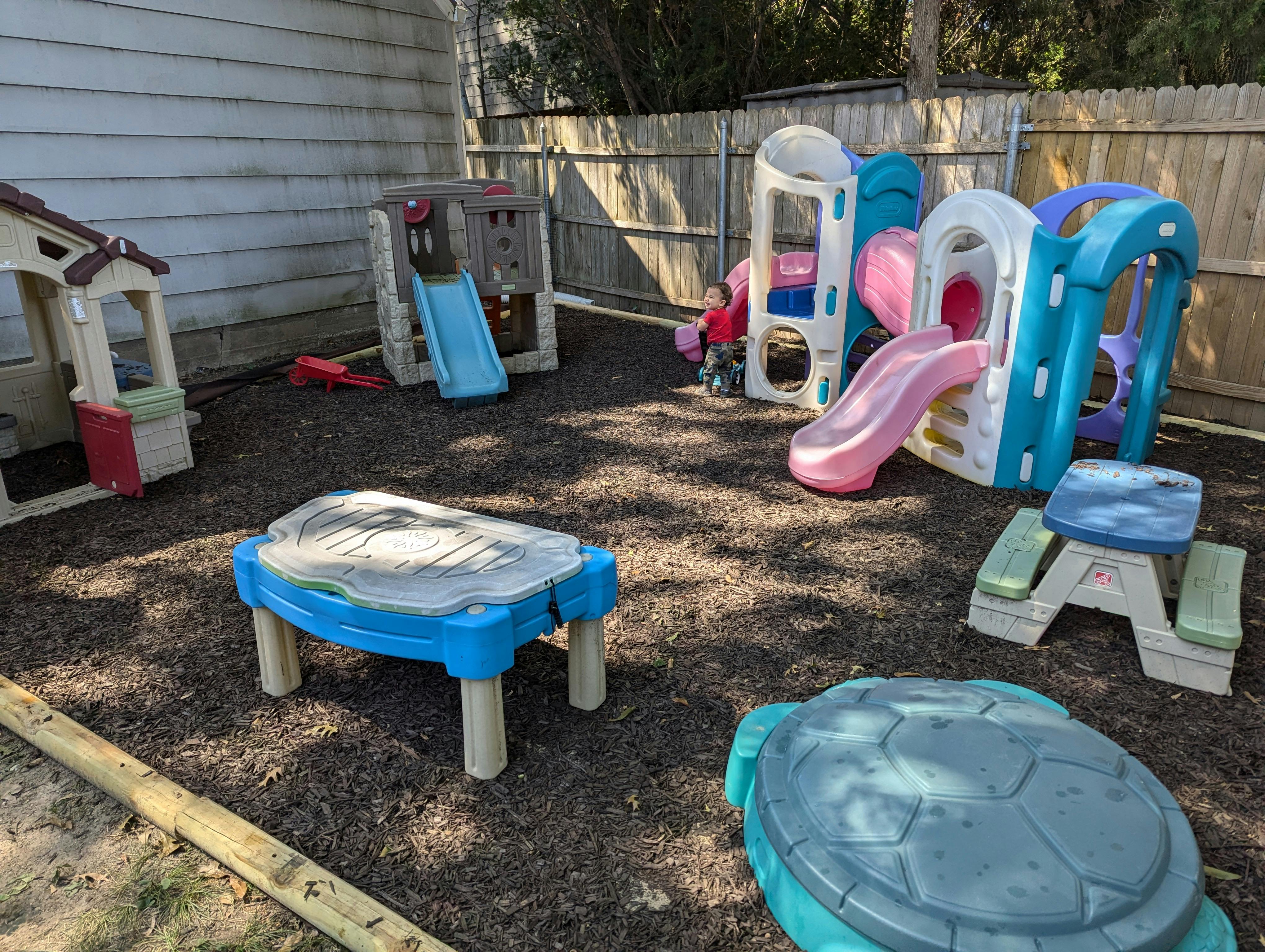 Outdoor playground with various play structures and a child