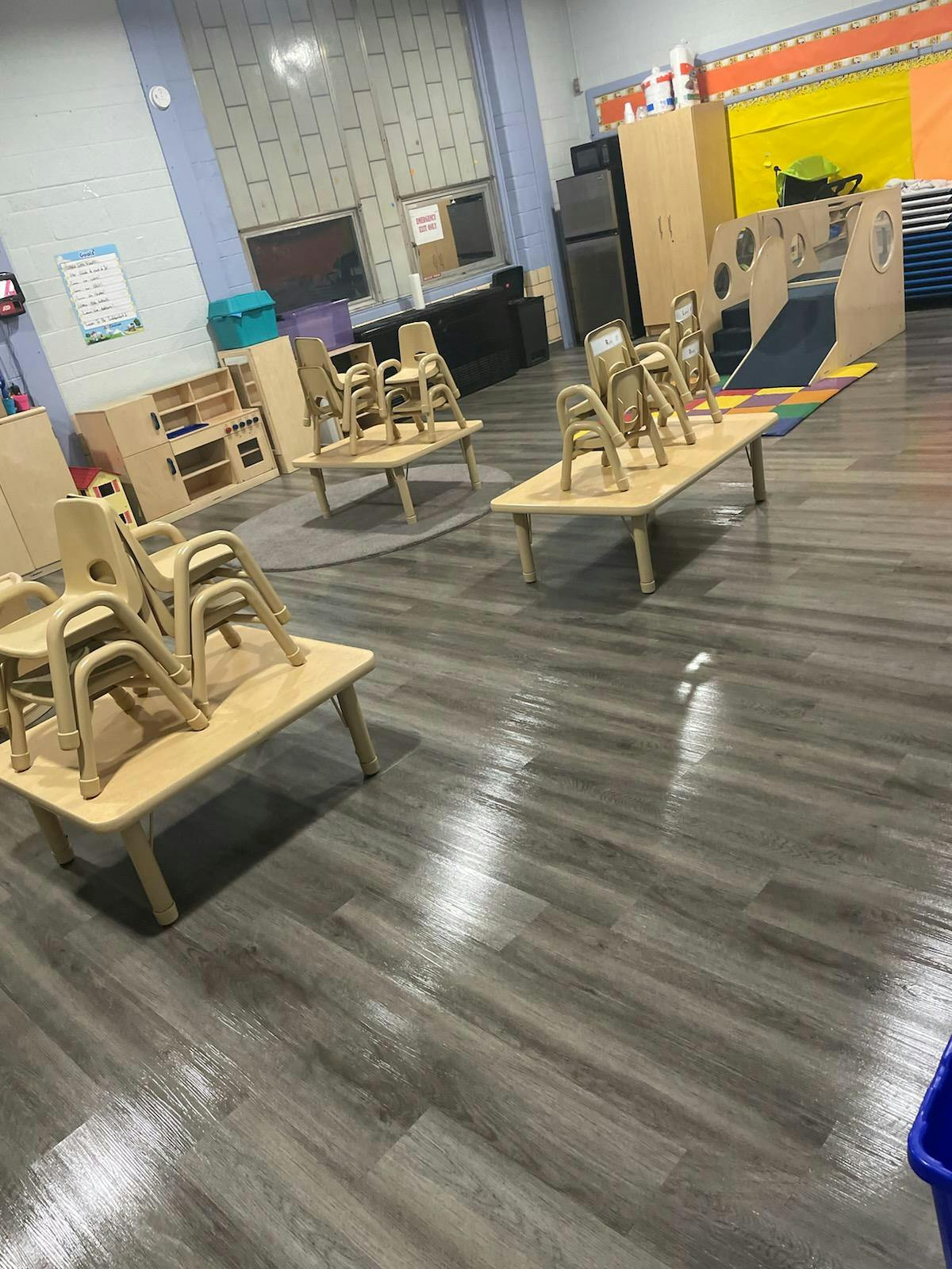 Classroom with small tables and stacked chairs