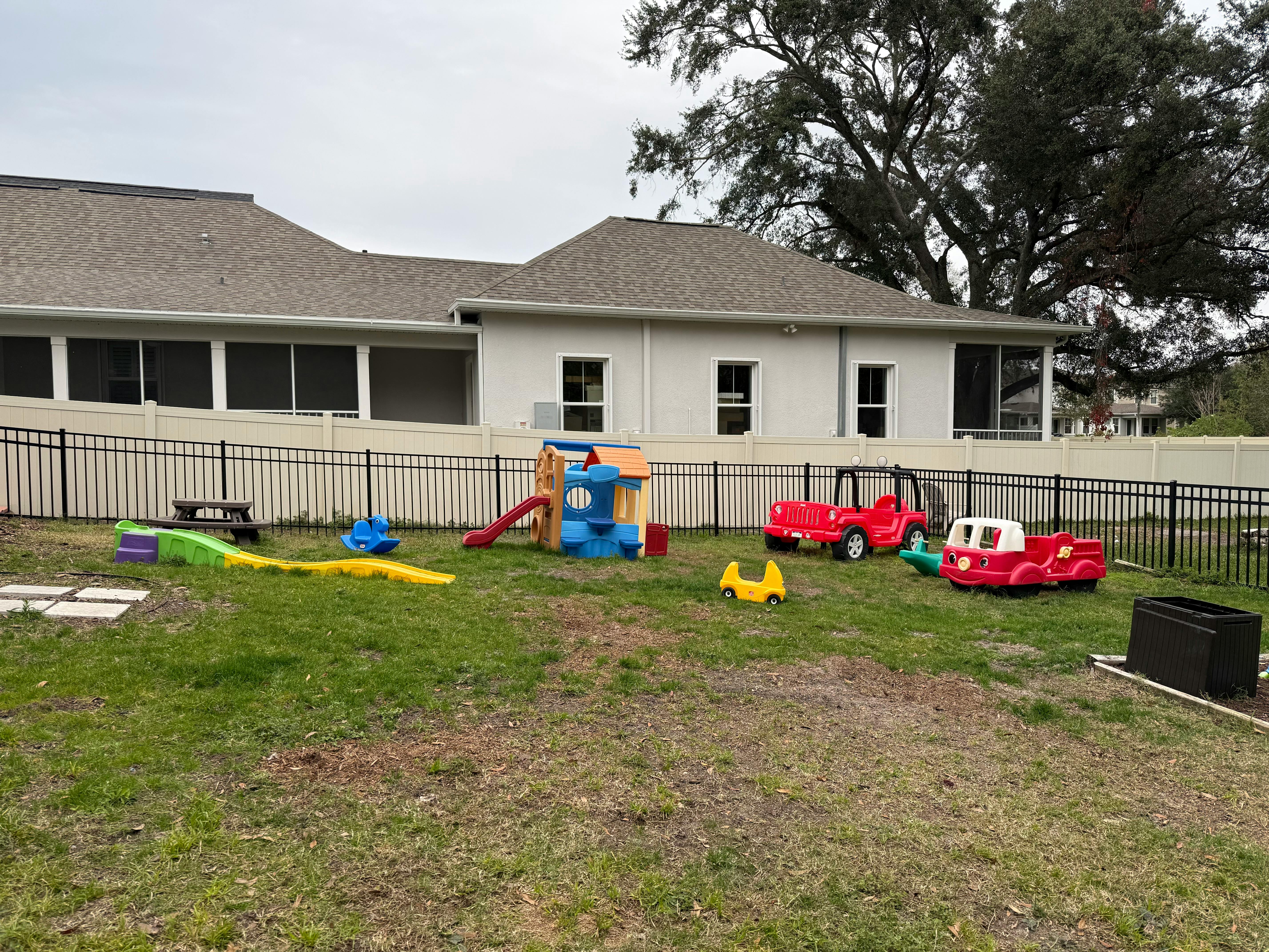 Outdoor playground with colorful play structures and ride-on toys