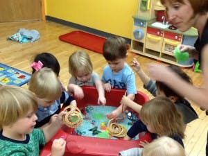 Adult and children playing with water table