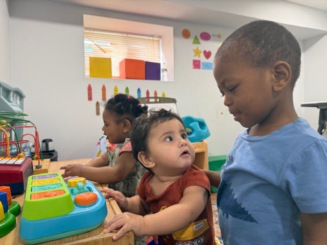 Three children playing with toys in a room