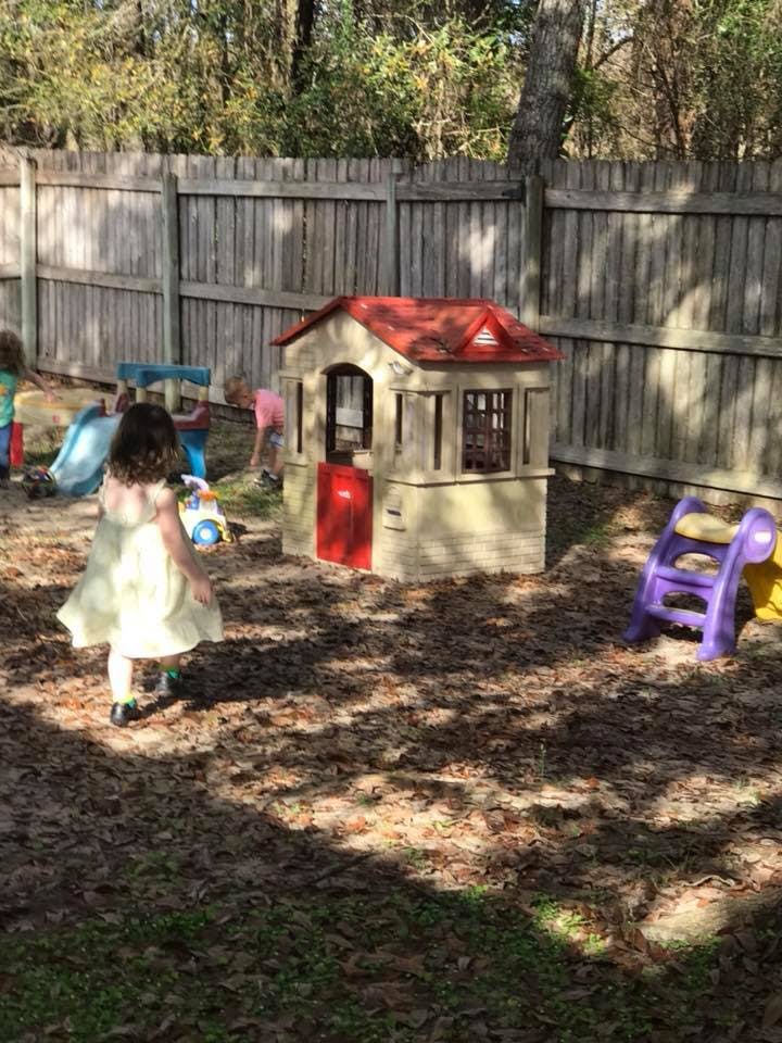 Child walking towards a playhouse in a yard