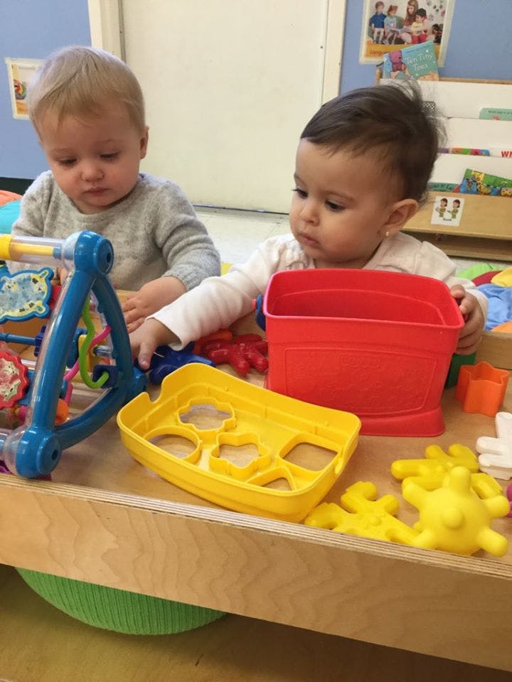 Two children playing with toys at a table