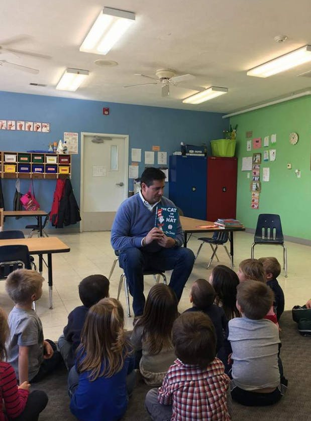 Person reading "The Cat in the Hat" to children in a classroom