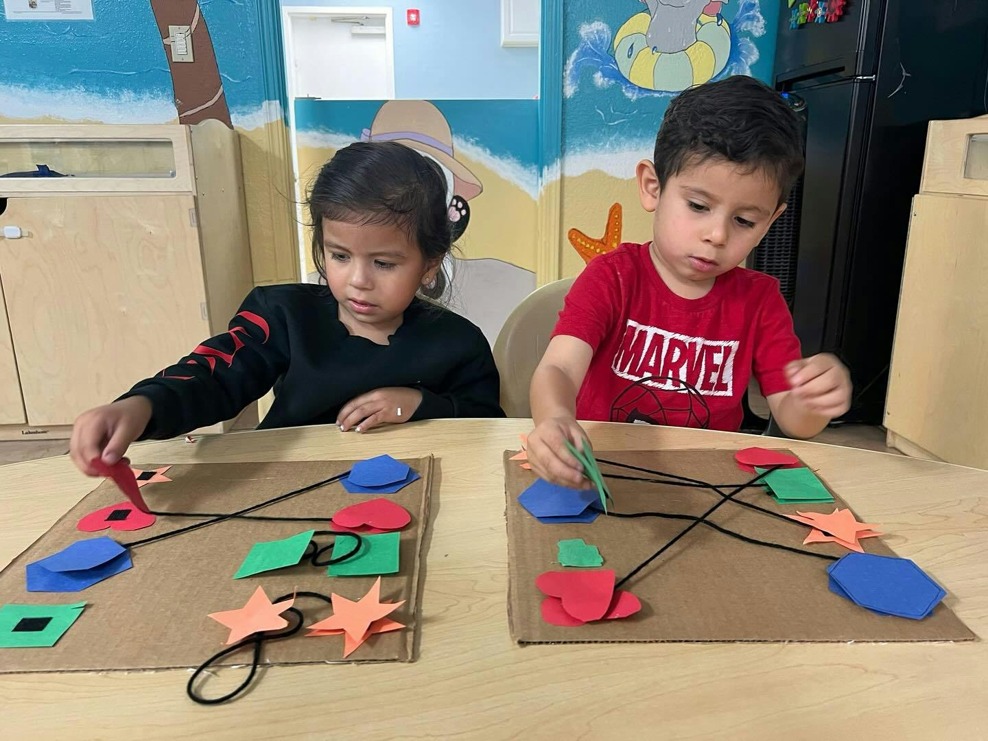 Two children playing with shape matching boards