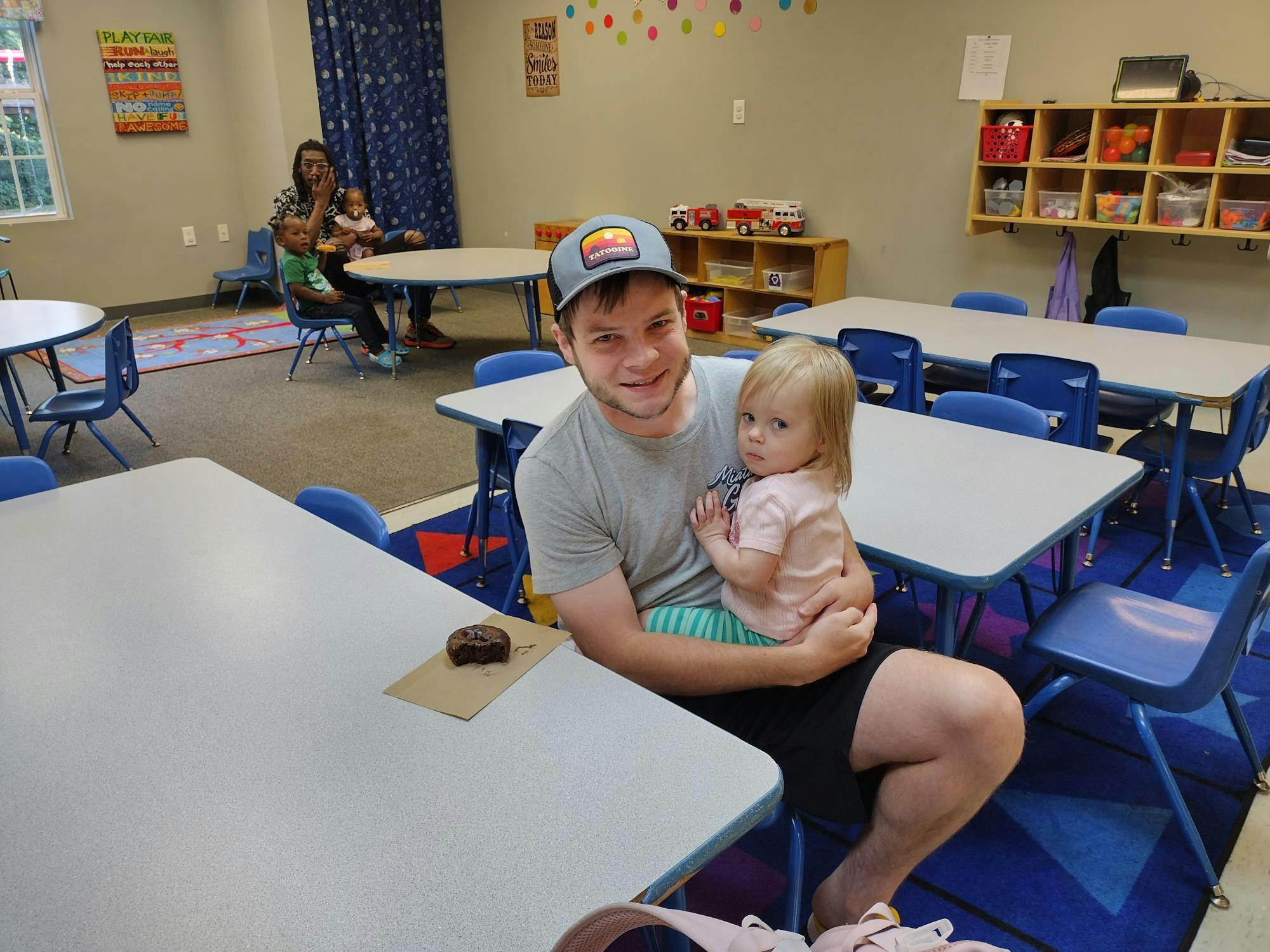 Person holding a child in a classroom