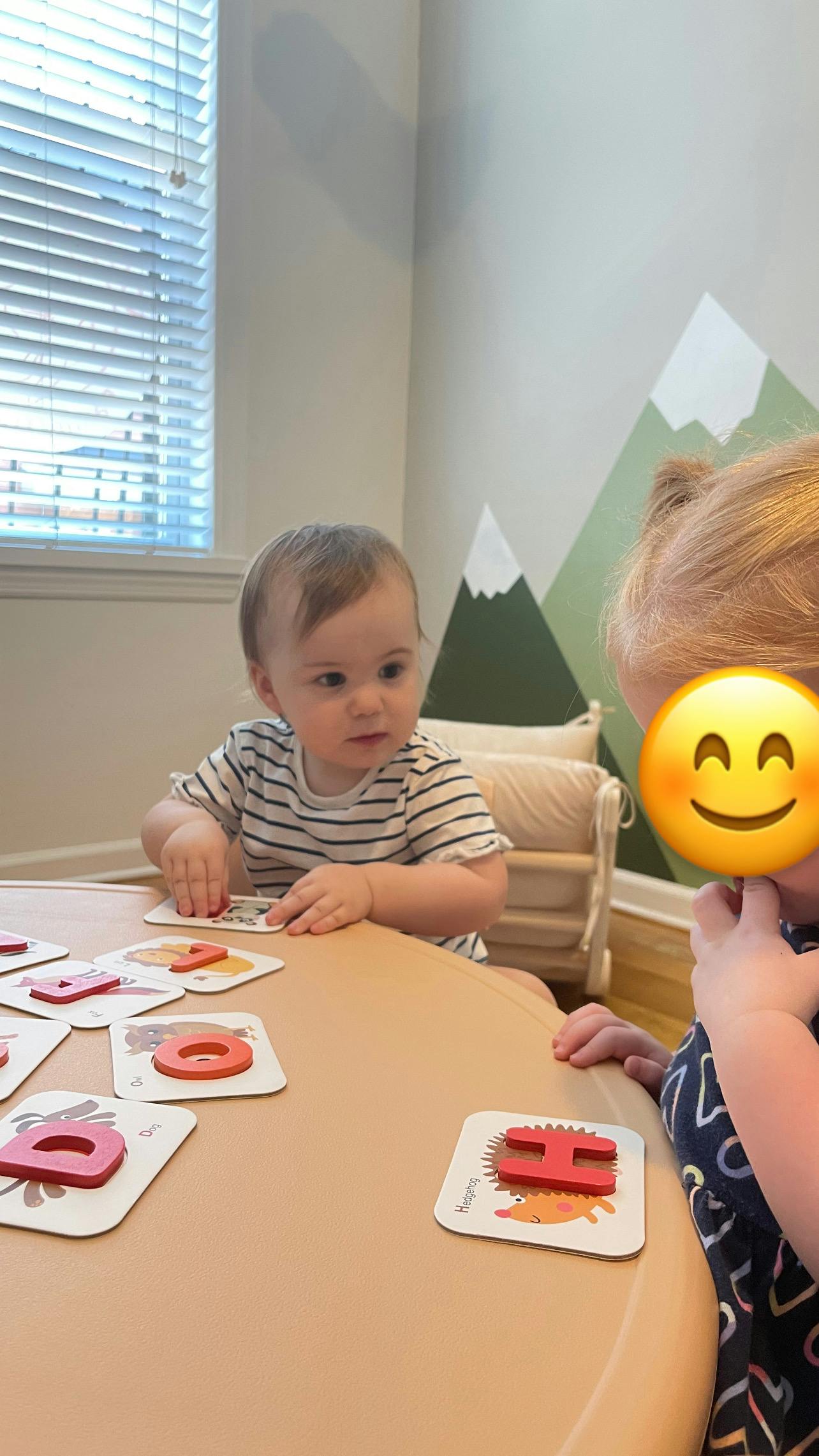Child playing with letter puzzle pieces on a table