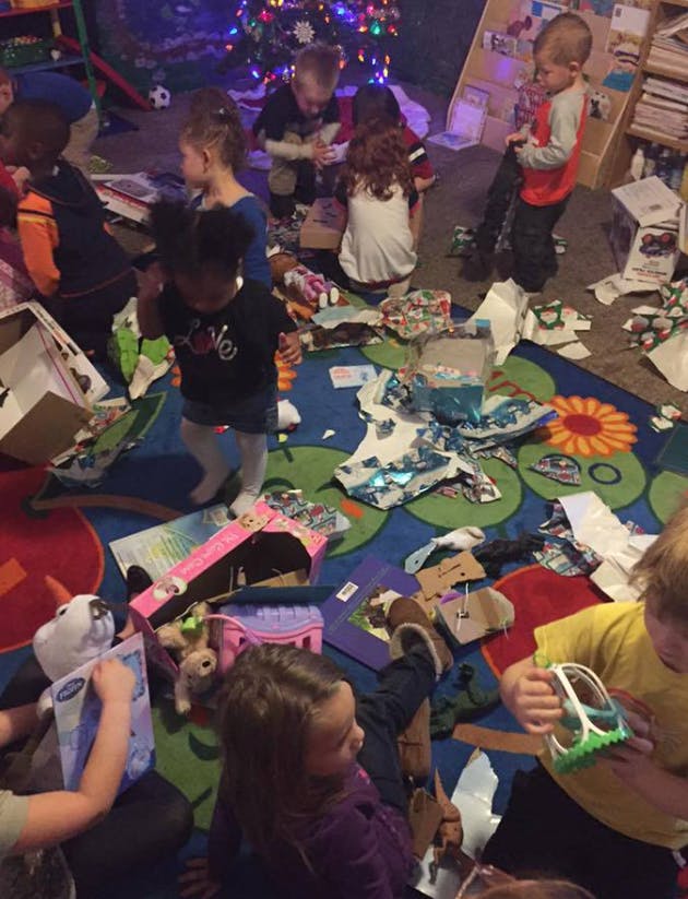 Children opening gifts on a colorful rug