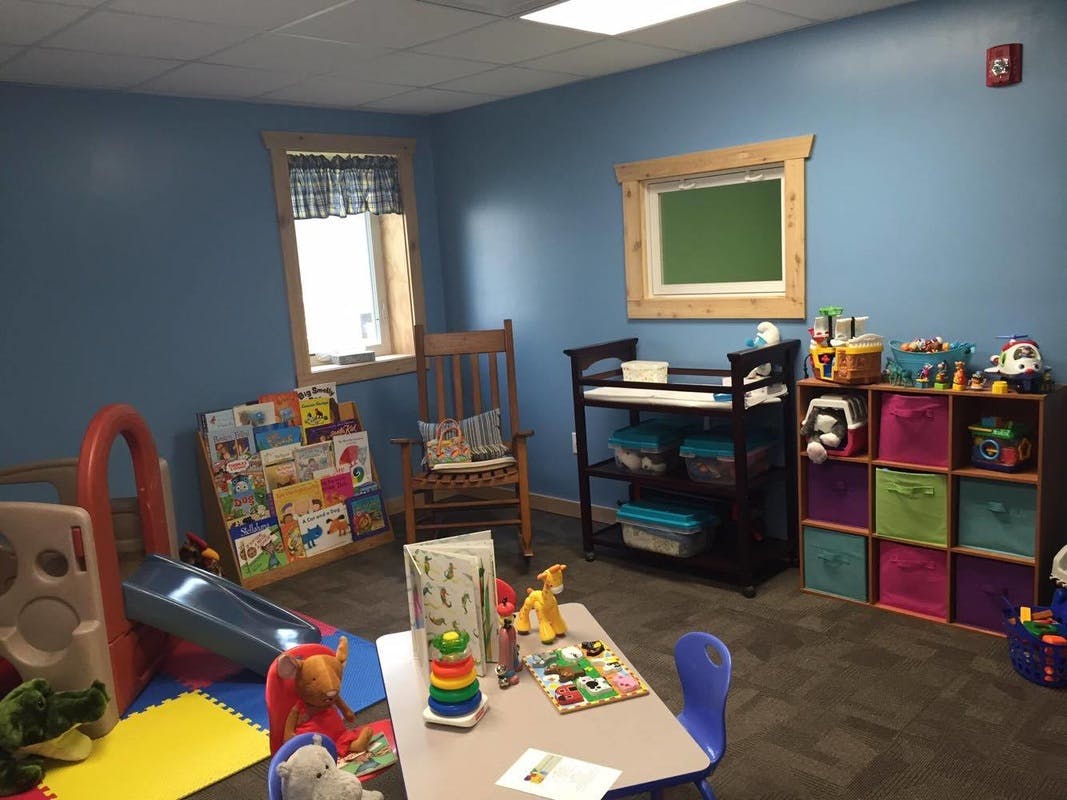 Playroom with slide, table, chairs, and toy storage