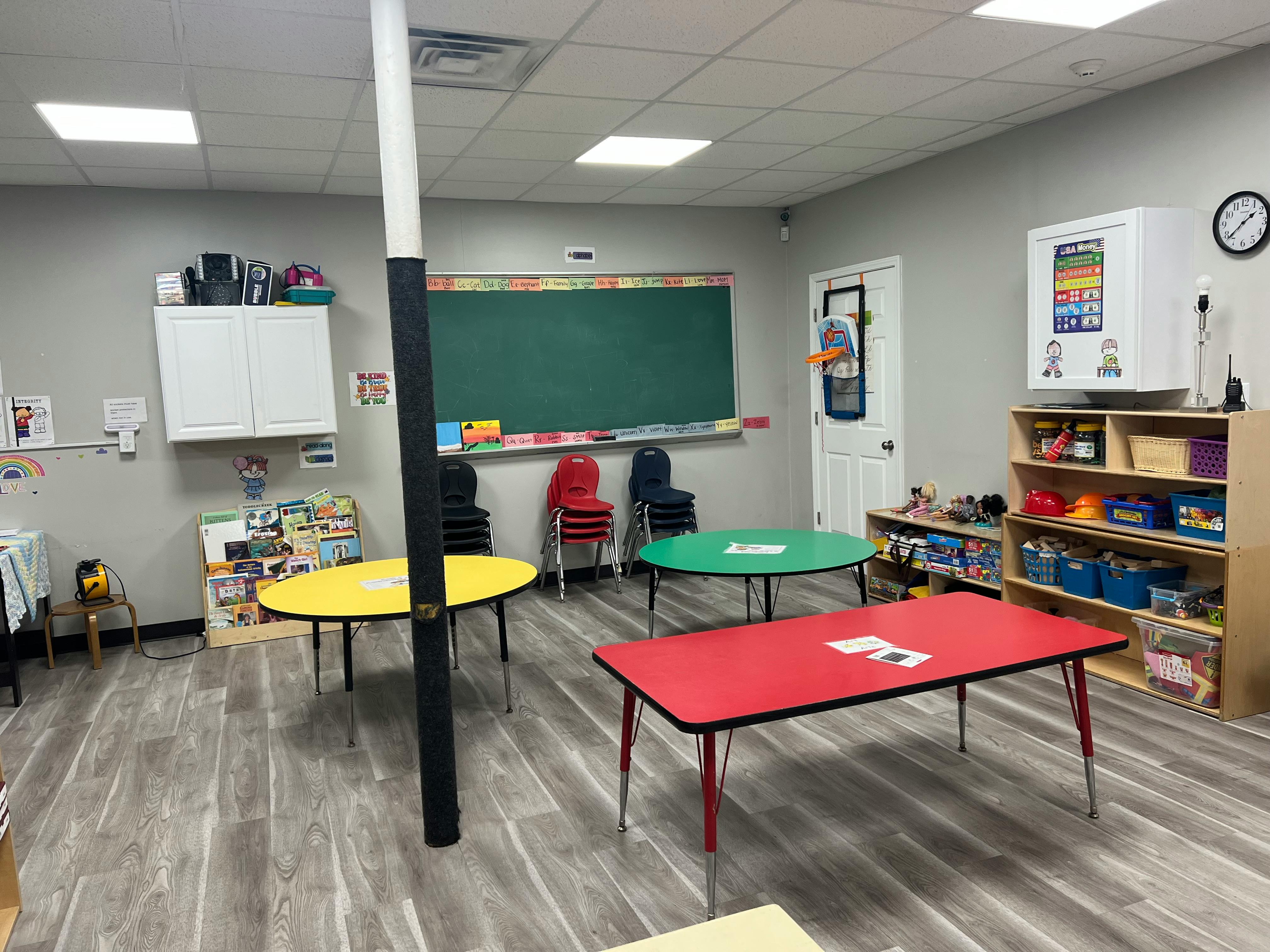 Classroom with colorful tables and a chalkboard