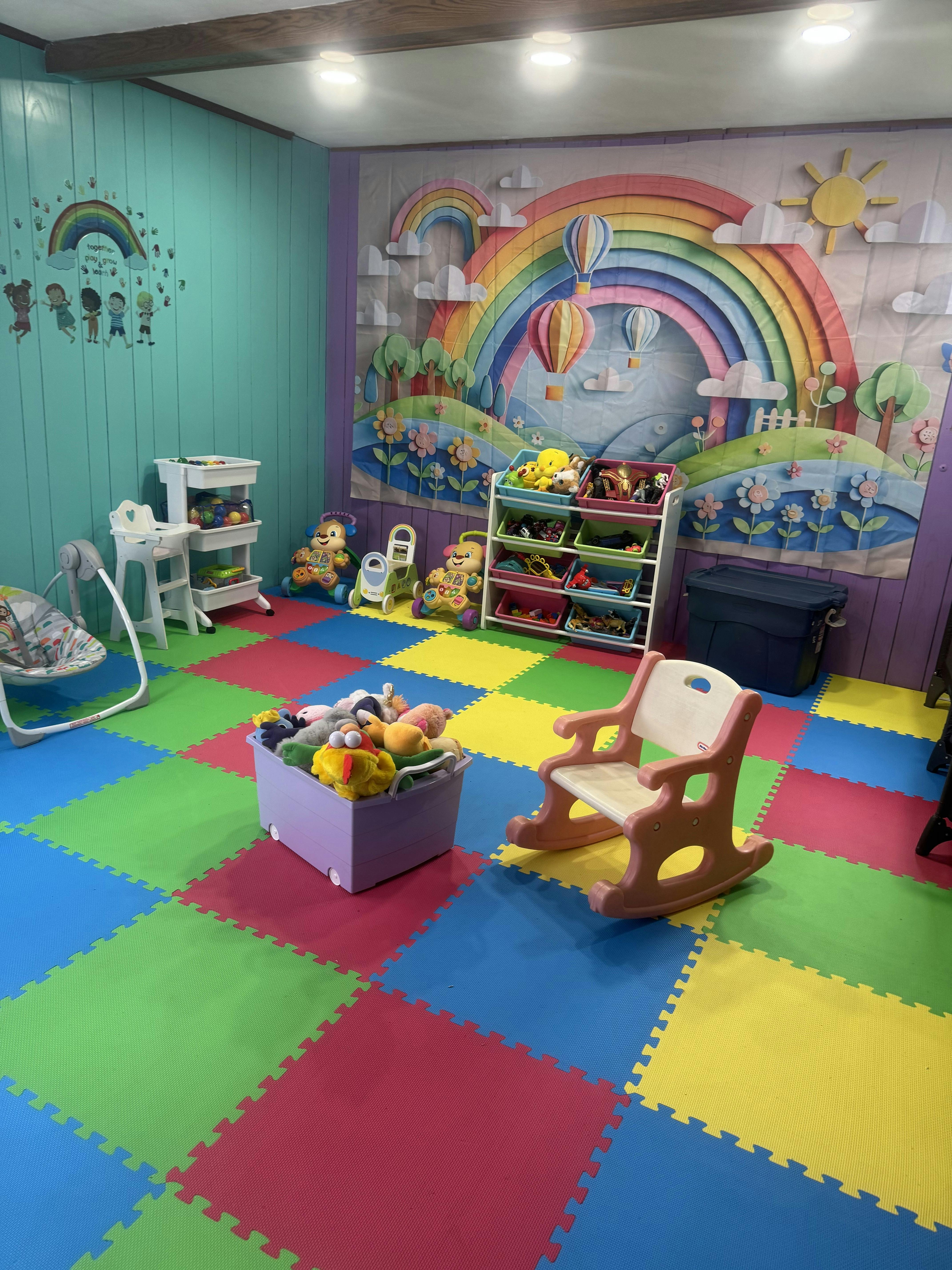 Colorful playroom with foam floor tiles, toys, and rainbow decor