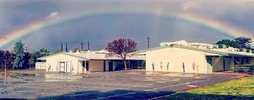 Rainbow over a building with a wet ground