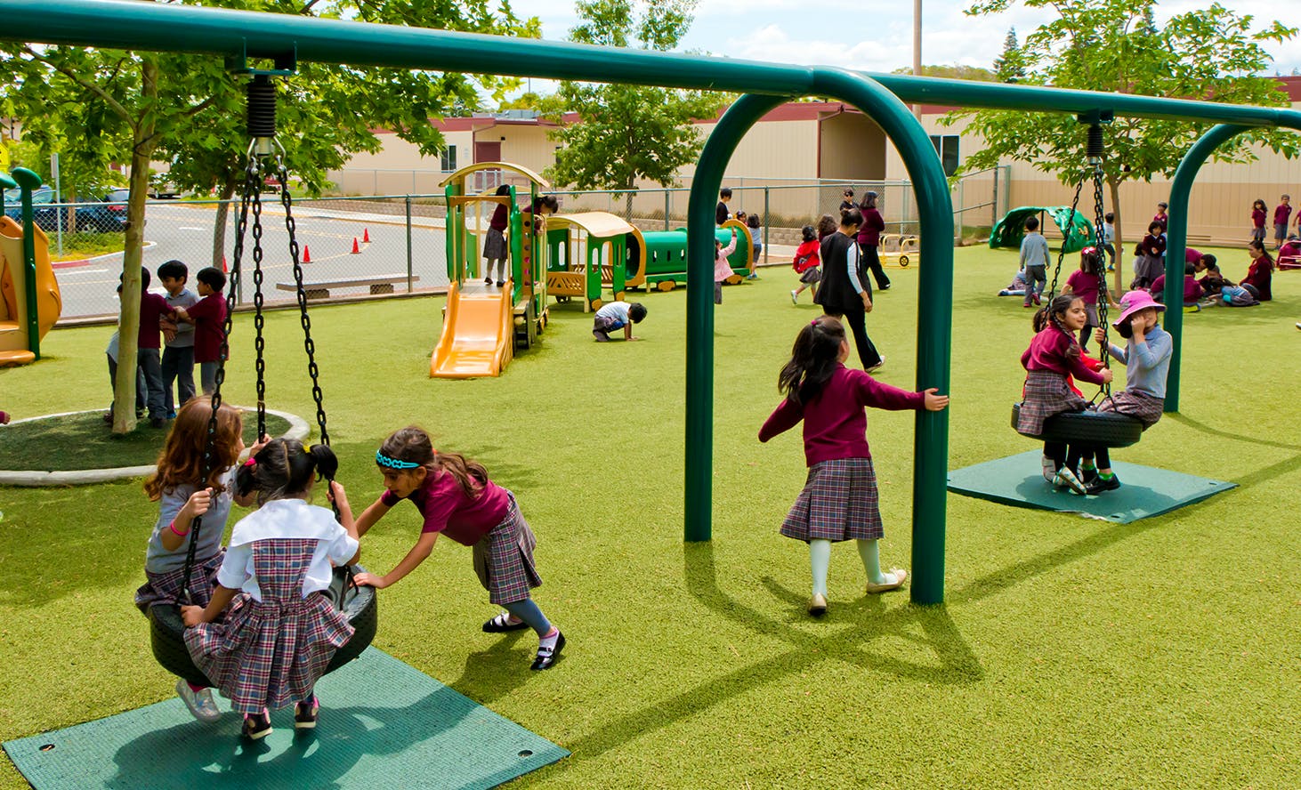 Children playing on swings and playground equipment
