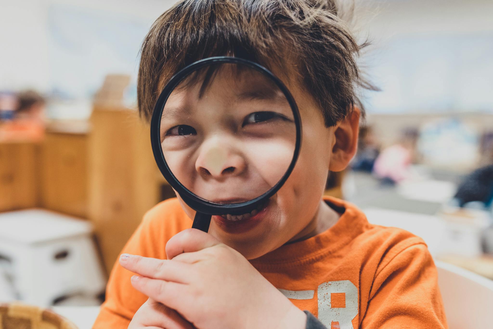 Child looking through a magnifying glass