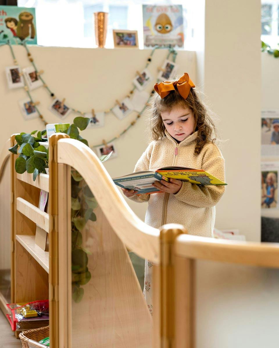 Child reading a book in a classroom