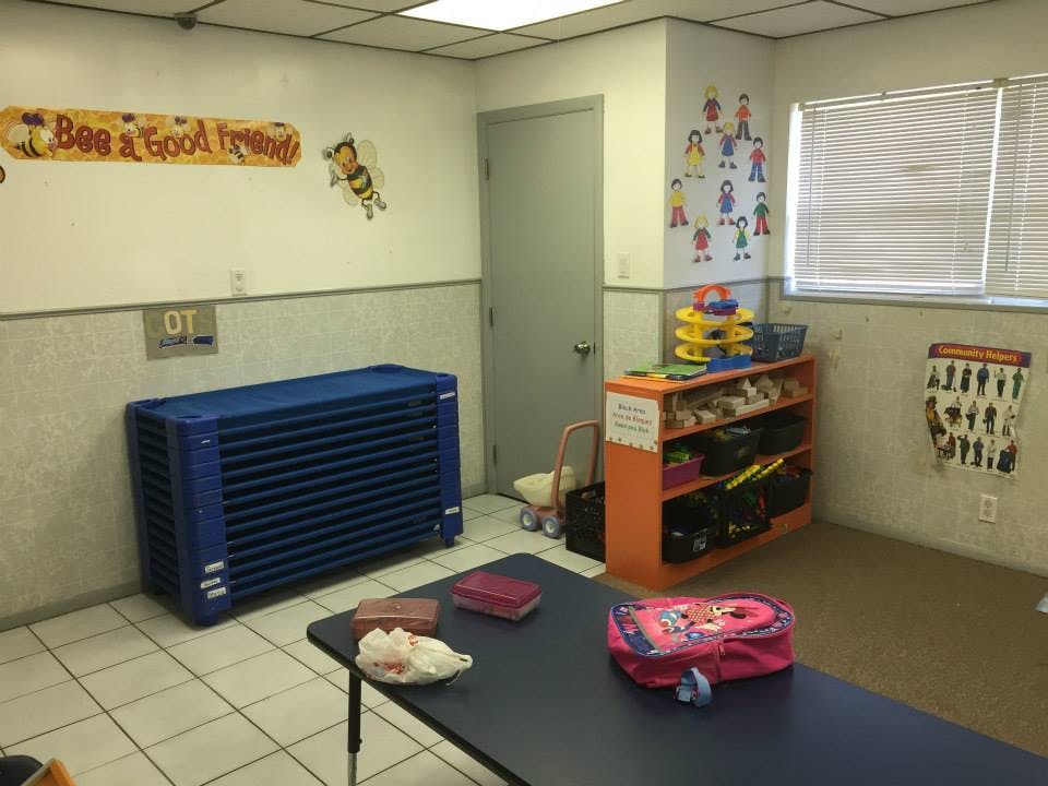 Classroom with blue storage unit, orange shelf, and table
