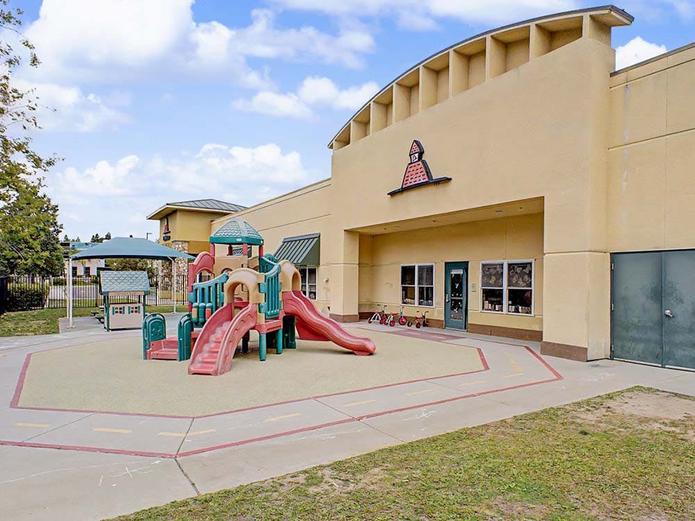 Playground with slides and climbing structures outside a building