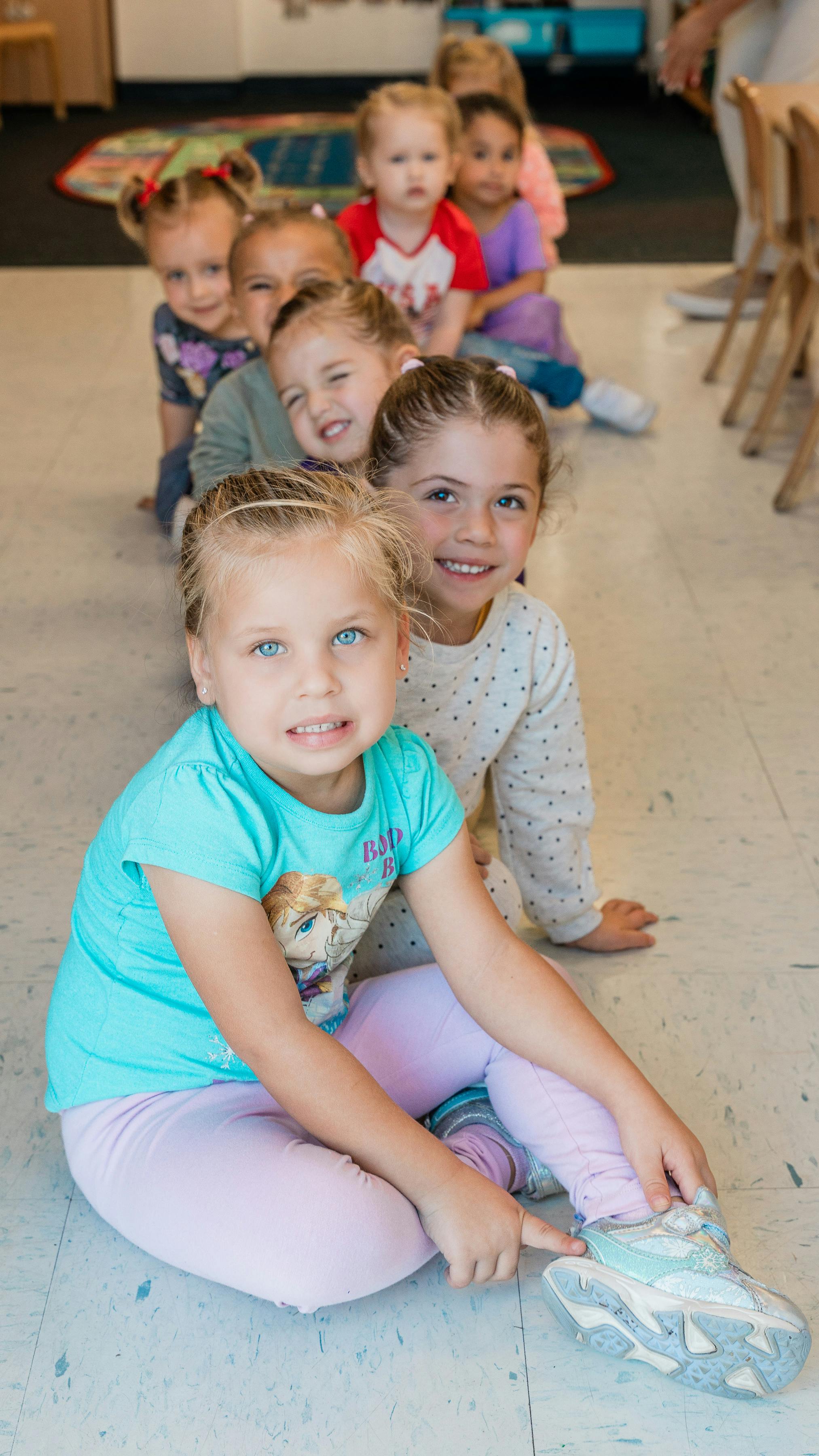 Children sitting in a line on the floor
