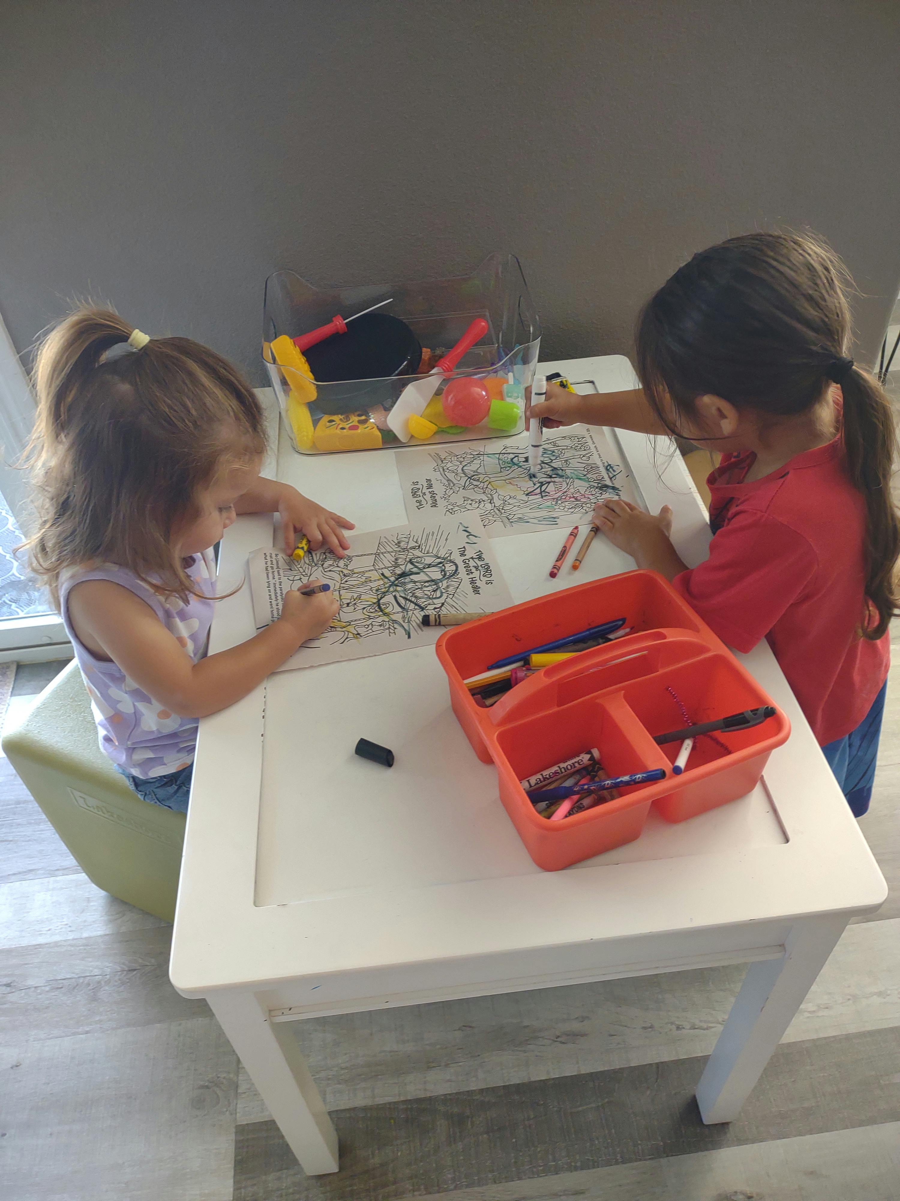 Two children coloring at a table