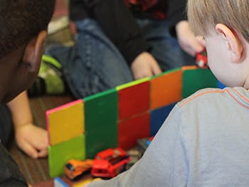 Children playing with colorful blocks and toy cars