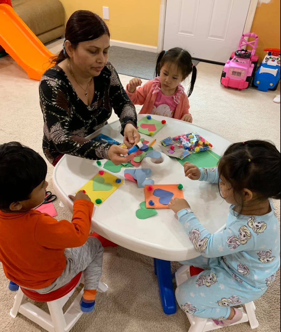 Adult and three children doing crafts at a table
