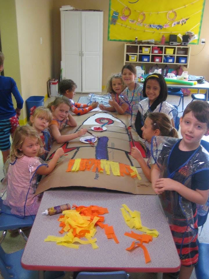 Children gathered around a table working on a craft project