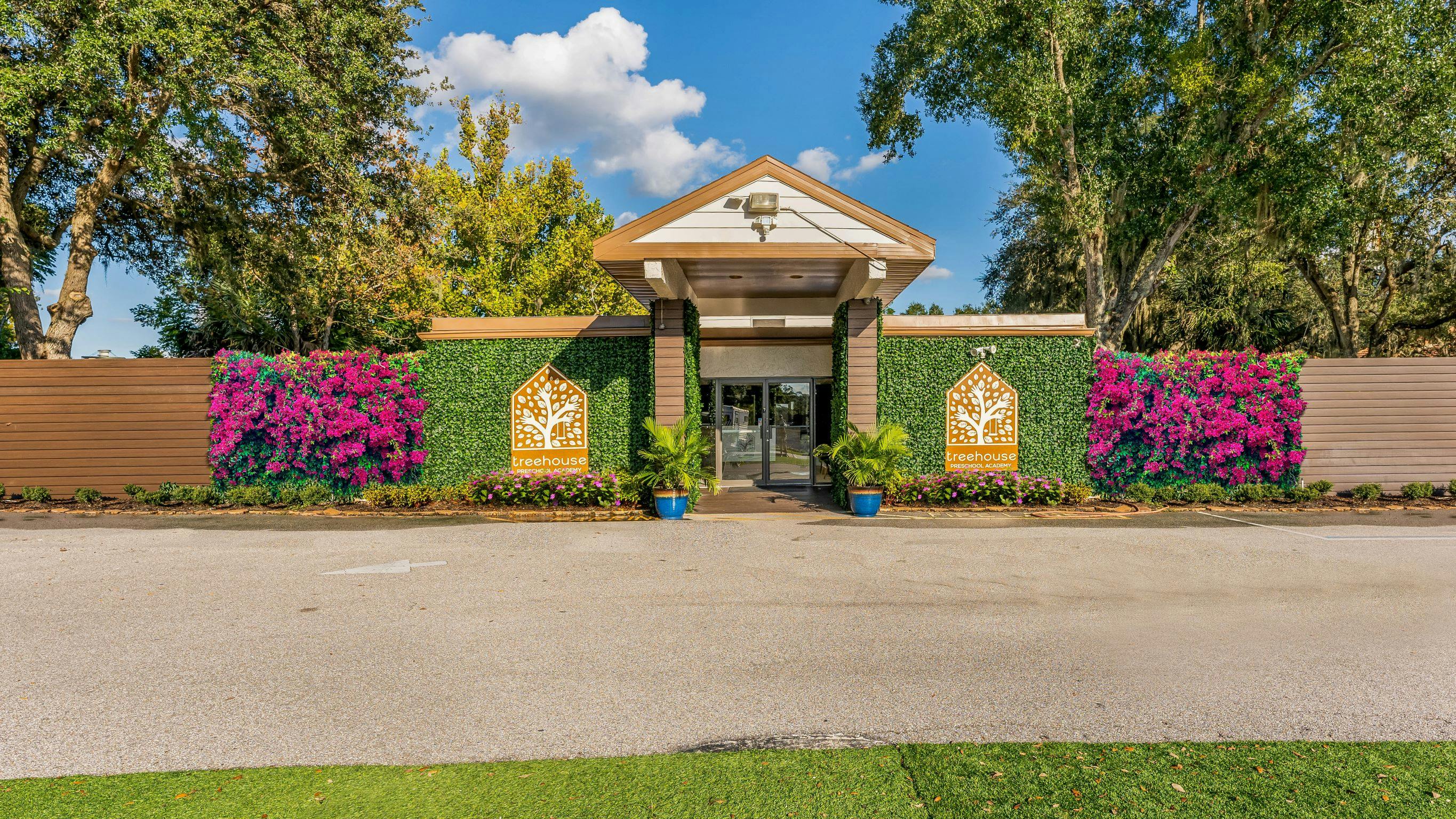 Building entrance with green wall and pink flowers