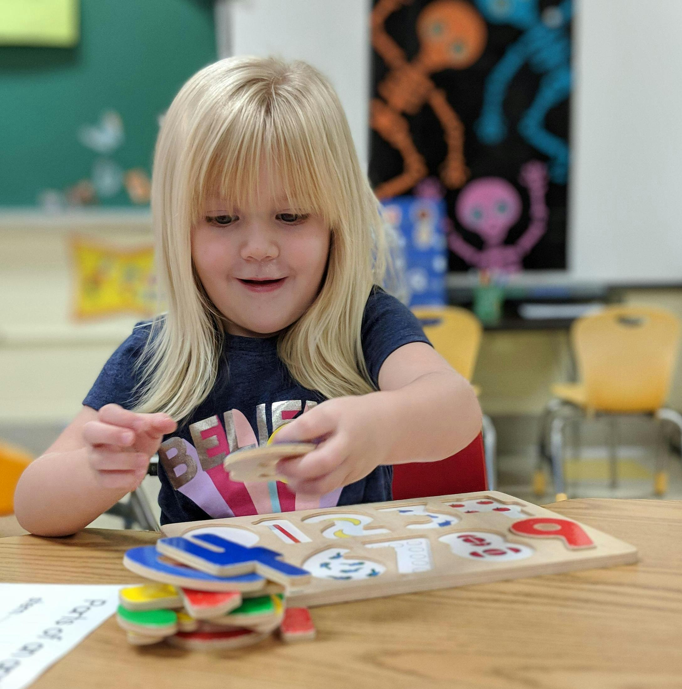 Child playing with a number puzzle at a table