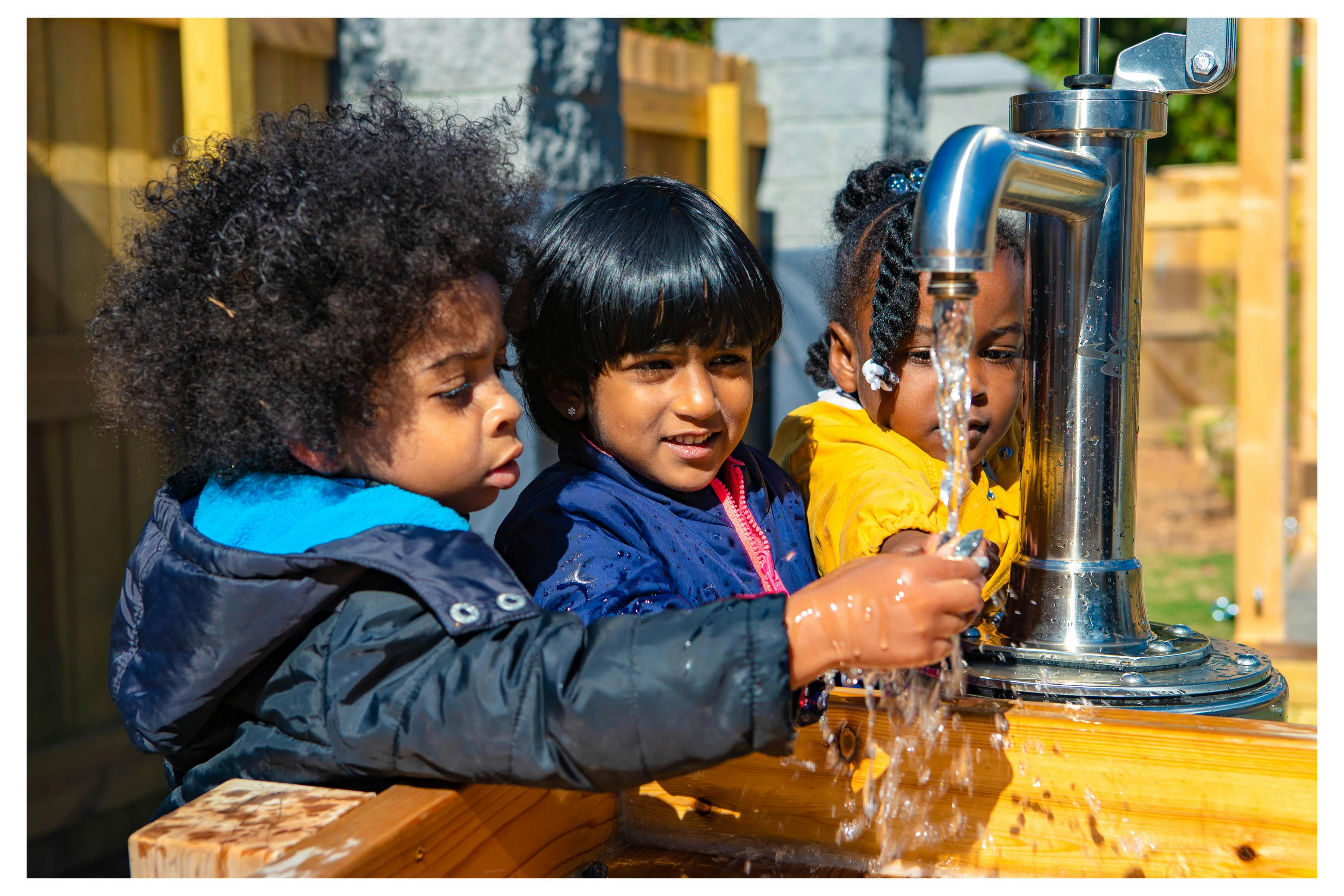 Children playing with water from a tap