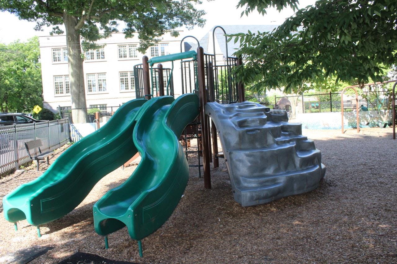 Green slides and climbing steps on a playground
