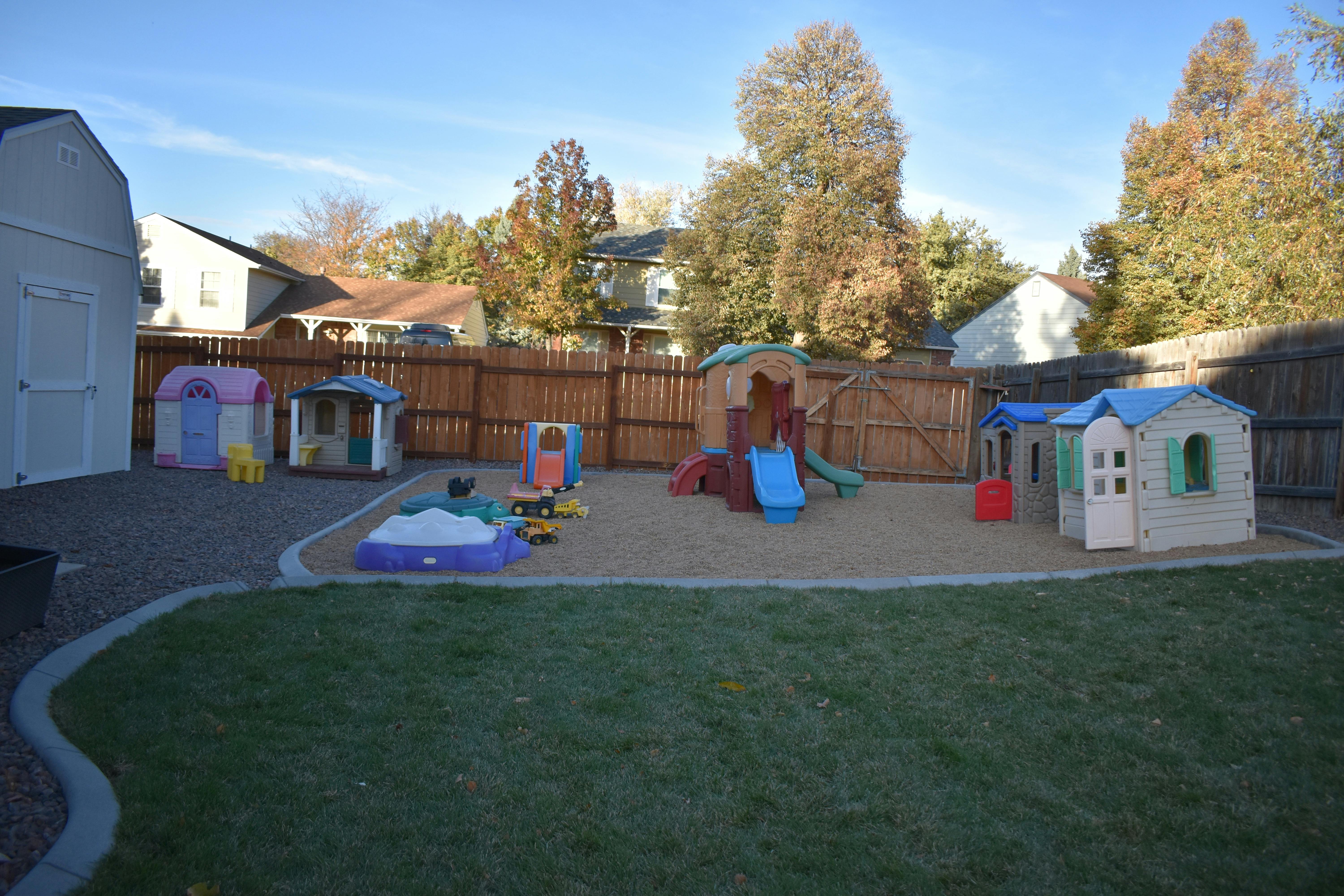 Outdoor playground with playhouses, slides, and sand area