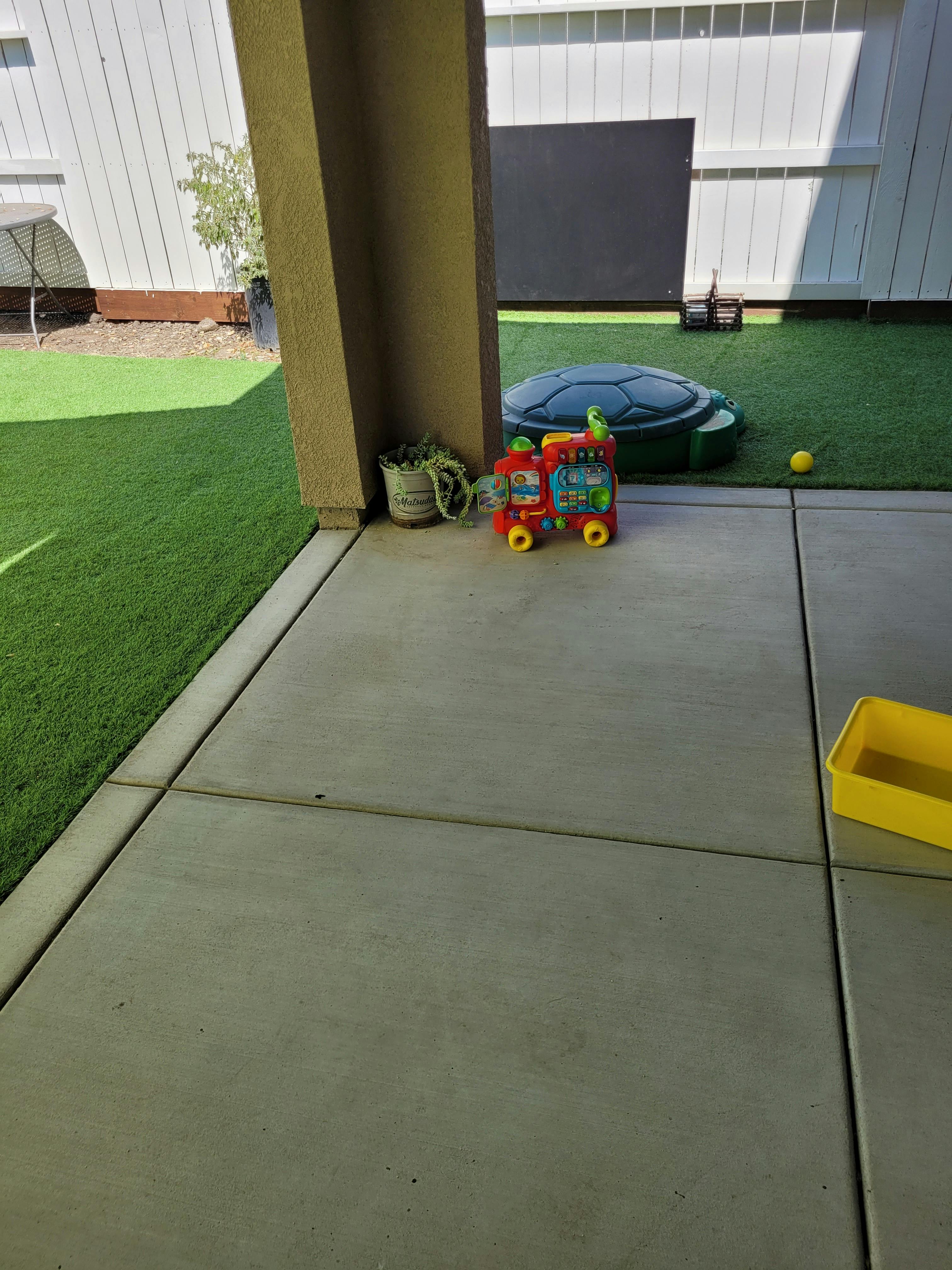 Toy train and turtle sandbox on a patio
