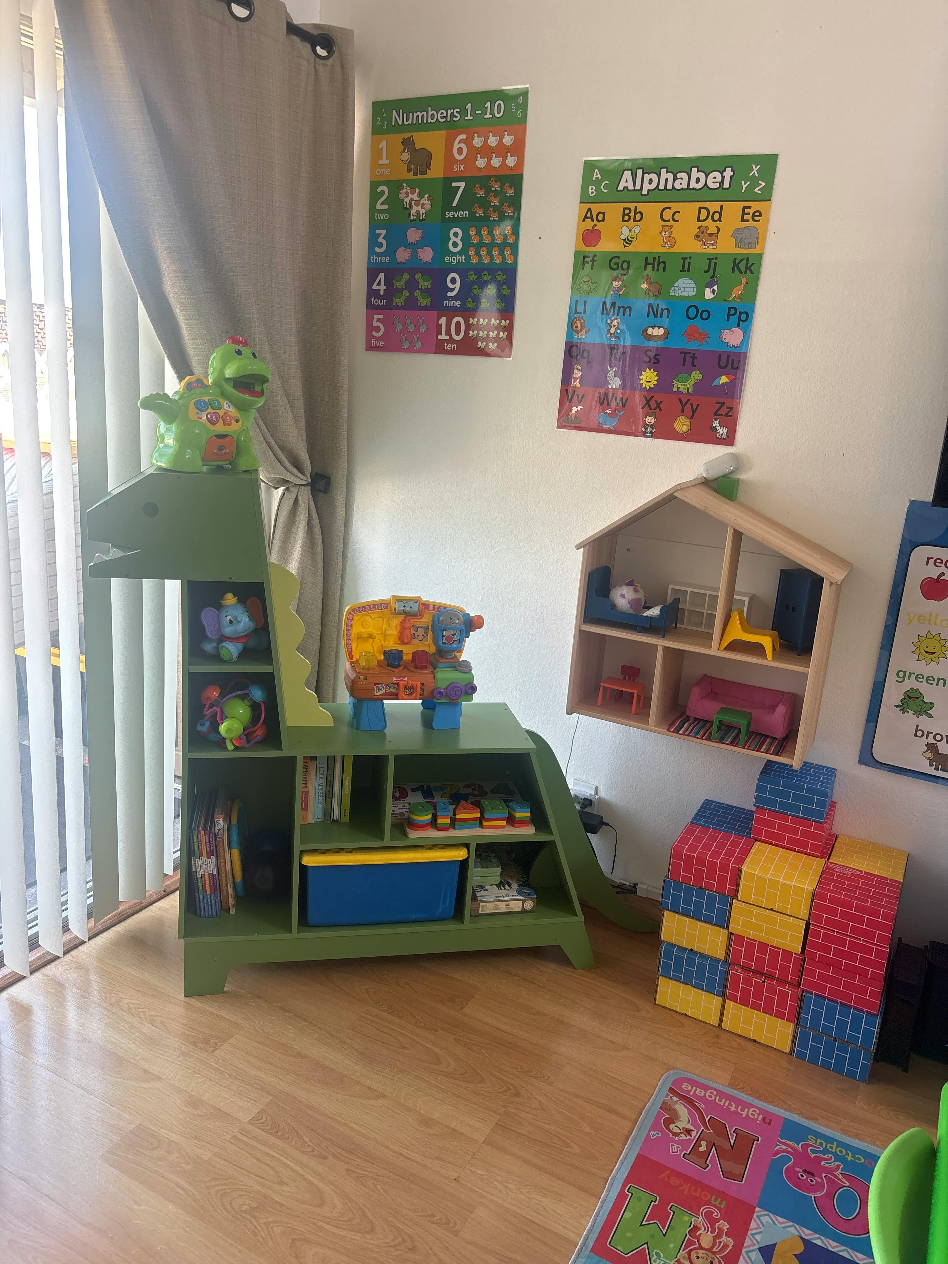 Children's room with alphabet and number charts, dollhouse, blocks, and toys
