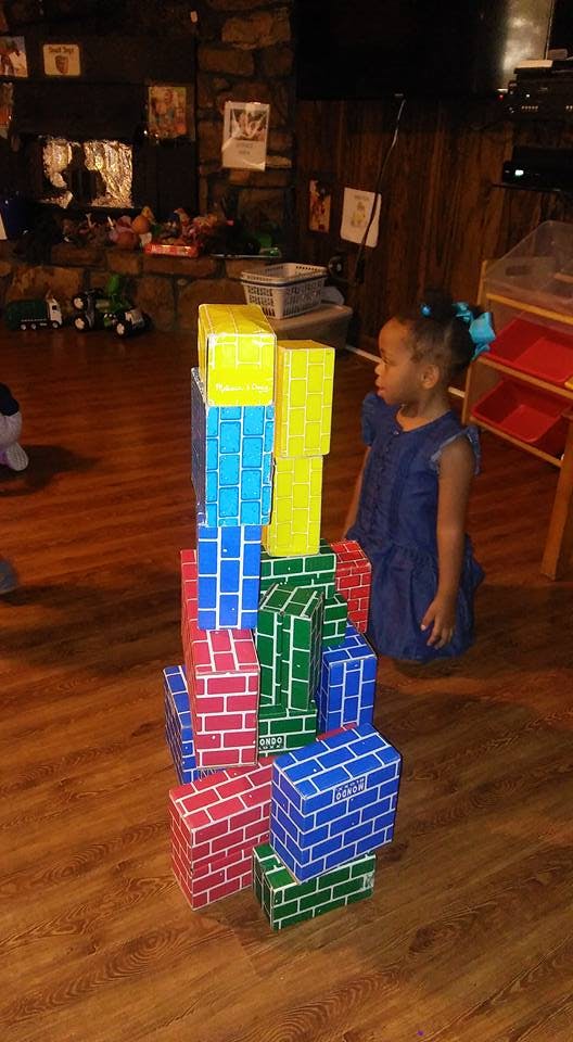 Child looking at a stack of colorful toy blocks