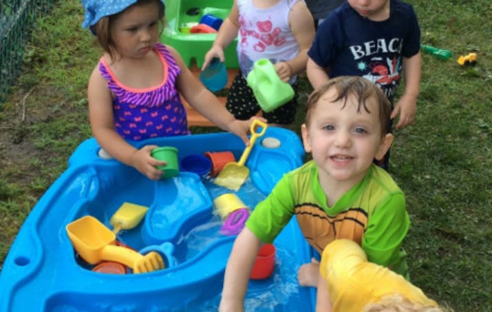 Children playing with water table and toys