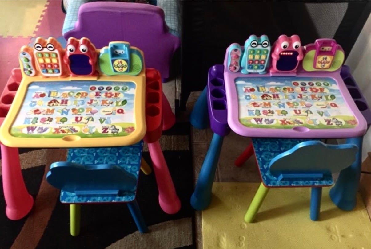 Two colorful children's learning tables with alphabet displays and attached chairs