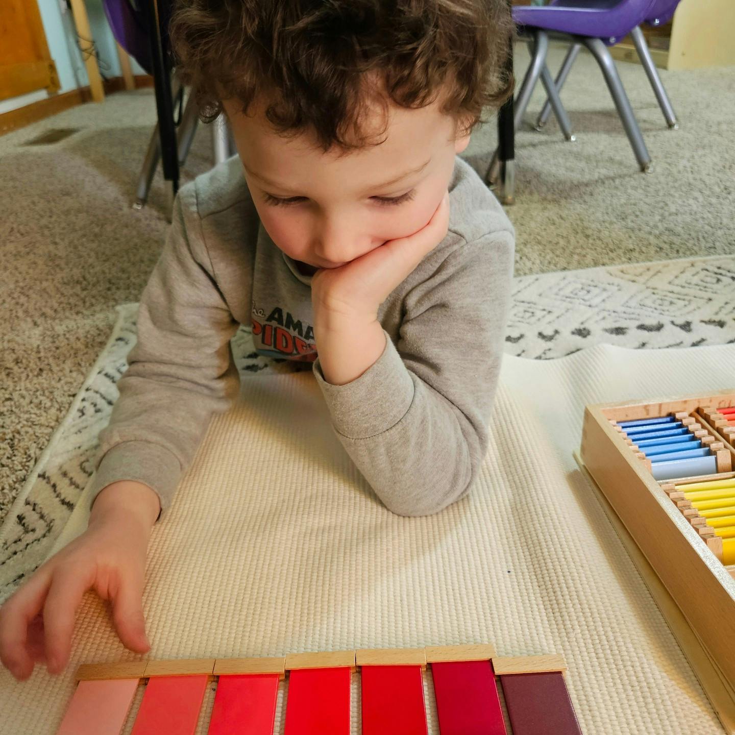 Child looking at a color sorting activity