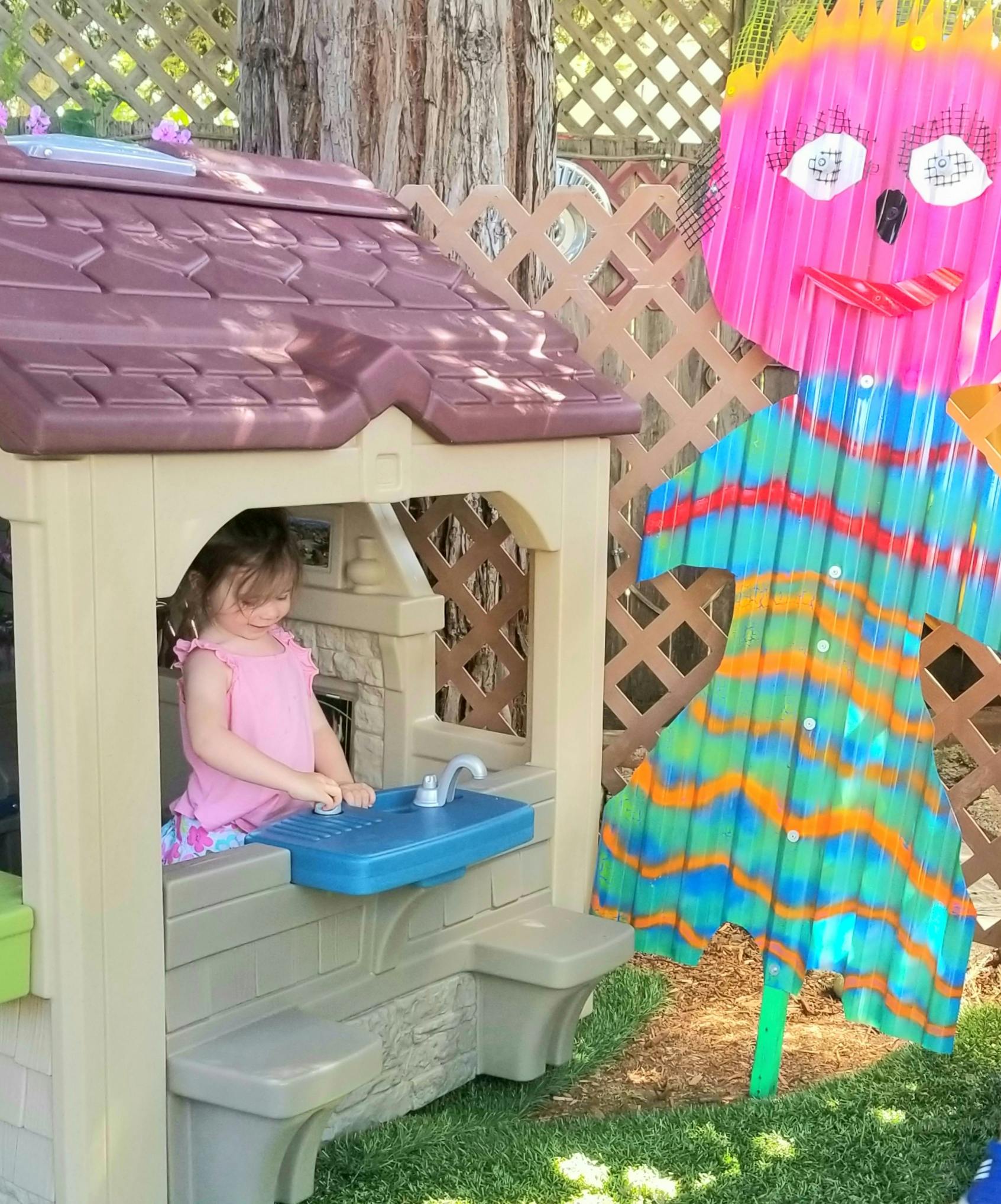 Child playing with a toy sink in a playhouse