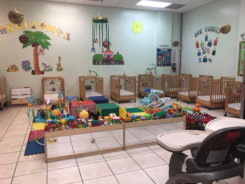 Nursery room with multiple cribs, play mats, and toys