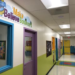 School hallway with colorful doors and a sign that says Make Believe Boulevard