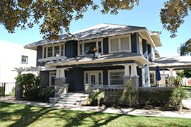 Two-story house with a porch and trees