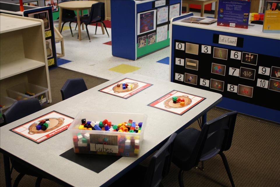 Classroom table with counting mats and a bin of colorful connecting cubes