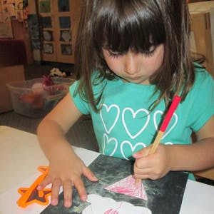Child drawing on paper with a pencil